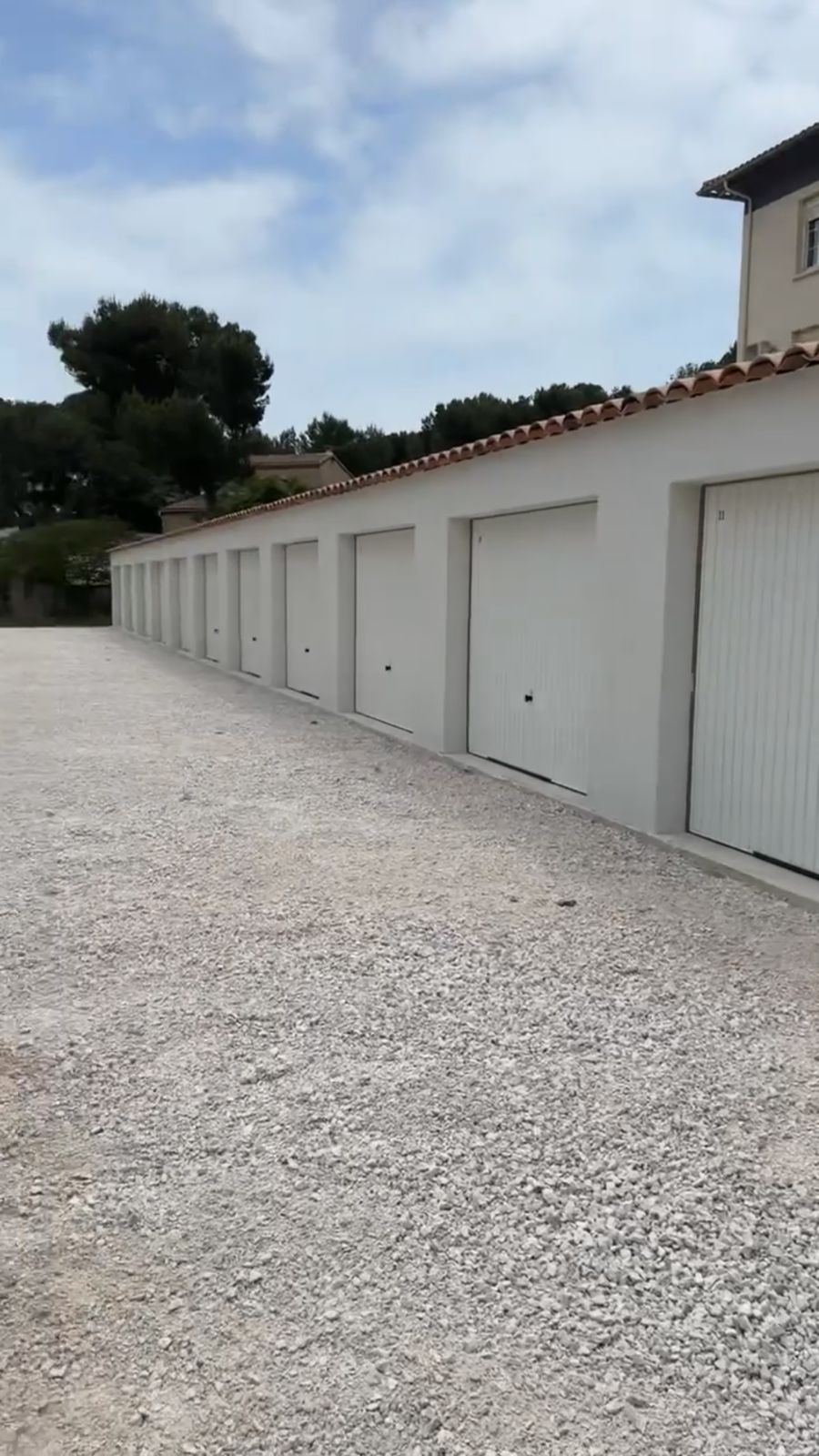Rangée de garages terminés, façade enduite blanche et portes