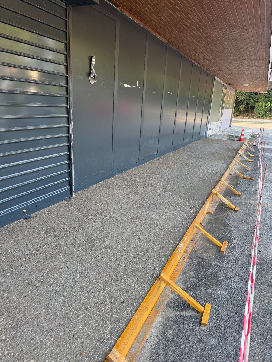 Dallage en béton le long d'une façade de local, coffrage en bois en place